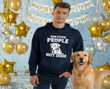 Man wearing a hoodie with a dog graphic and text, standing next to a dog with festive decorations in the background.