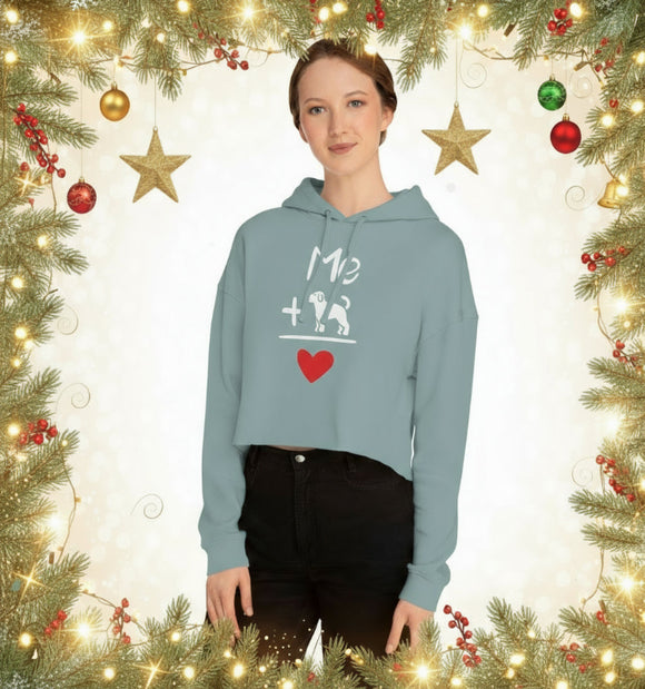 Person wearing a light blue hoodie with a graphic design in front of Christmas decorations.