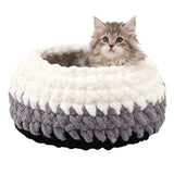 Cat lying on a fluffy white and gray pet bed against a white background