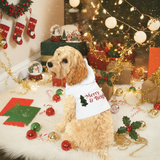 Dog wearing a 'Merry & Bright' bandana in front of a Christmas tree with lights and presents.